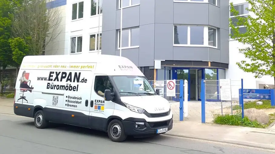 Lieferwagen von Expan Büromöbel GmbH bei der Auslieferung von Büromöbel vor einem Bürogebäude 